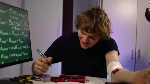 Student tunes wearable implant while checking biometric data in tech lab Stock Footage 324443427