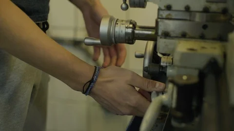 Student turning knobs in a machine shop Stock Footage 103336931