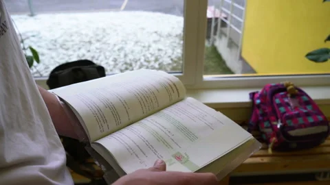 Student turns pages of a maths book at school near the window Stock Footage 236119208