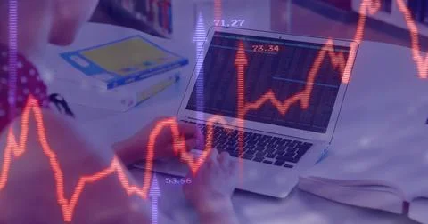 Student typing stock data on laptop in study room, with stock graph overlay, Stock Photos