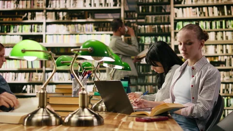 Student in university library distracted by smartphone notification Stock Footage 336358716