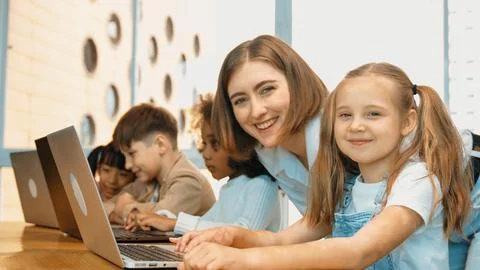 Student use laptop writing code while teacher explain about program. Erudition. Foto stock