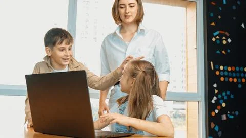 Student use laptop writing code while teacher looking at screen. Erudition. Stockfoto's