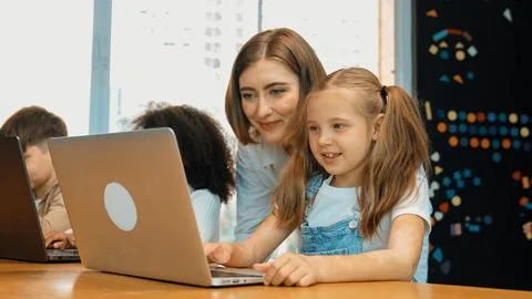 Student use laptop writing code while teacher explain about program. Erudition. Foto stock