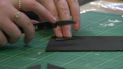 A student uses a blade to cut a piece of material Stock Footage 239652634