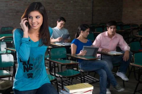 Student using the cellphone on the class Stock Photos