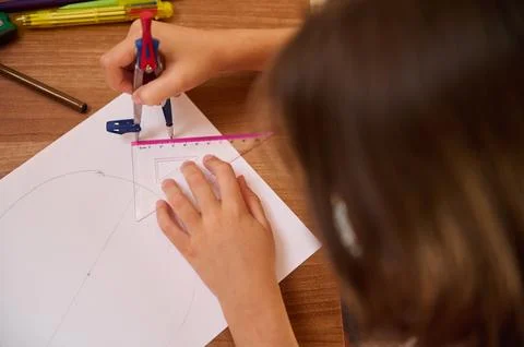 Student Using Compass and Ruler for Geometry Drawing on Desk Surface Stock Photos