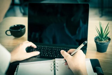 Student using computer for learning leasson online at cafe. startup man writi Stock Photos