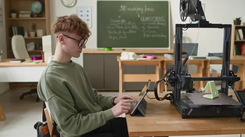 Student Using Digital Tablet to Control 3D Printer in School Classroom Stockbeeldmateriaal 335694851