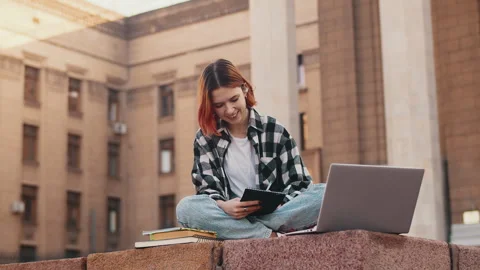 Student using digital tablet taking notes studying outdoors Stock Footage 282723859
