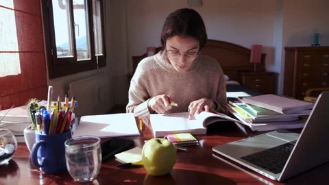 Student using her phone surrounded by books in her bedroom. Stock Footage 145811417