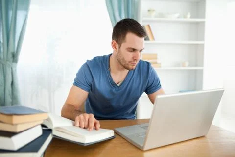 Student using his notebook to work through his subject material Stockfoto's