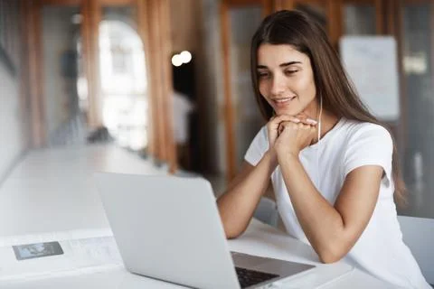 Student using a laptop computer to call parents abroad. Young woman using a Stock Photos