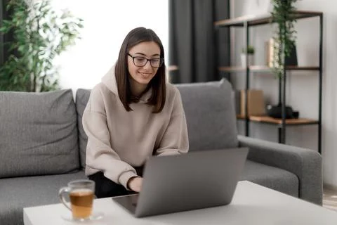 Student using laptop on couch Stock Photos