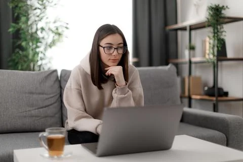 Student using laptop on couch Foto stock