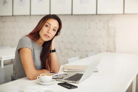 Student using laptop duting coffee brake. Portrait of posh young woman looking Stock Photos