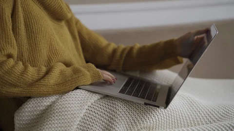Student using laptop at home lying on sofa under blanket using computer serching Stock Footage 119524531