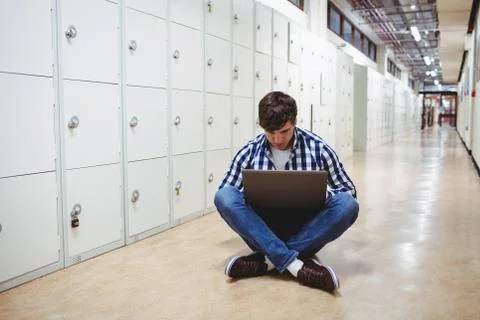 Student using laptop in locker room Stockfoto's