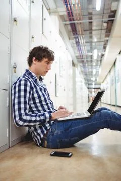 Student using laptop in locker room 写真素材