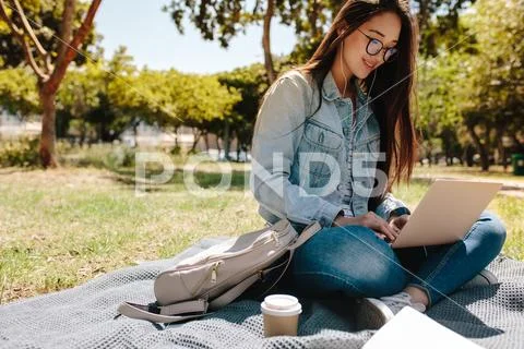 Student using laptop sitting in college campus Stock Photos