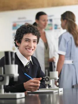 Student Using Microscope And Taking Notes In Laboratory Stock Photos