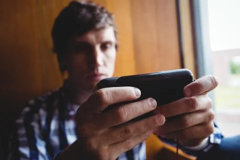 Student using mobile phone near window 스톡 사진