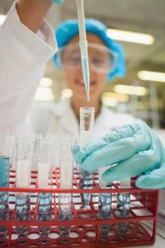 Student using pipette holding test tube with blue liquid Fotos Stock