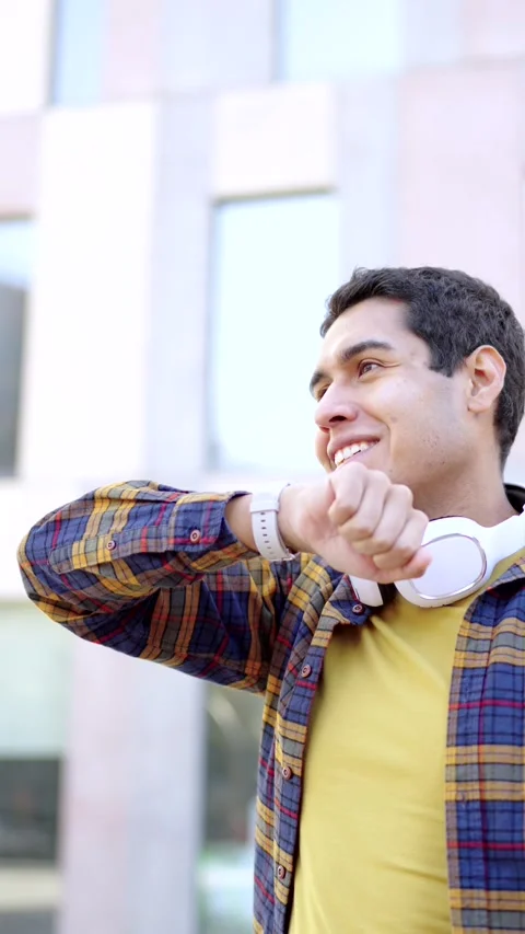 Student using a smart watch standing outside the campus Stock Footage 258325449