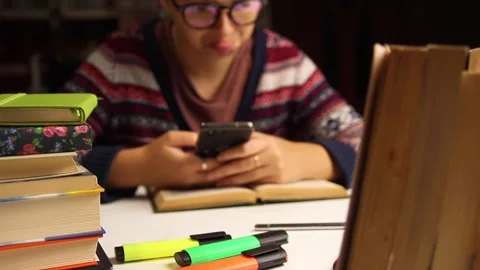 Student using smartphone instead of studying close up. Female student in gl.. Stock Footage 337346856