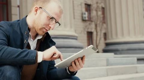Student using a tablet and revising for his exam while sitting Stock Footage 62408700