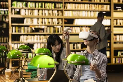 Student using VR device and controller to explore immersive learning at library Stock Photos