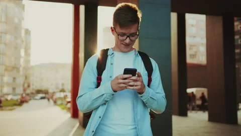 Student walking with smartphone. Portrait view of young man wearing glasses Stock Footage 141557462