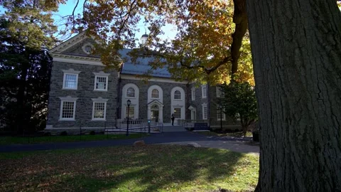 Student walking through college campus of old historic stone building Stock Footage 241833656