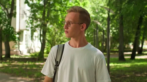 Student walking on university campus. Man walking on his way to college. Yo.. Stock-Footage 339526351