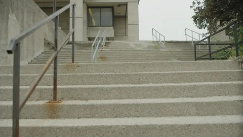 Student walks across steps in slow-motion wide shot Stock Footage 112884683