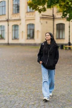 A student walks down the street with a backpack near the university Stock Photos