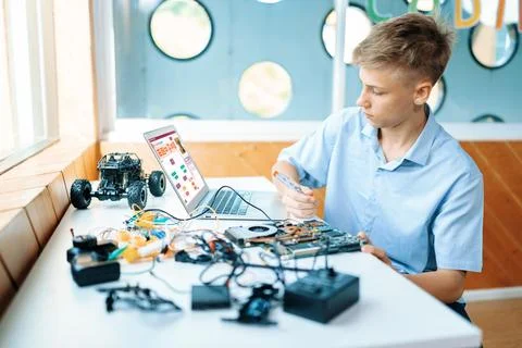 Student watch code on laptop and use screwdriver fix motherboard. Edification. Stock-Fotos