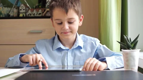 The student waves hello to the camera, smiles, then draws with a pencil on the Stock Footage 171933330