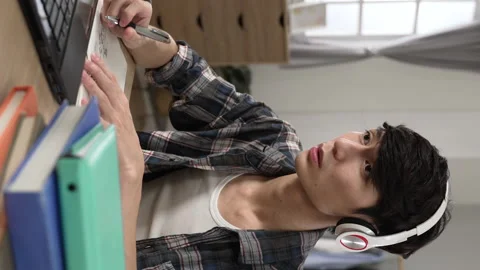 Student wearing headset is taking notes Vídeo Stock 230207468