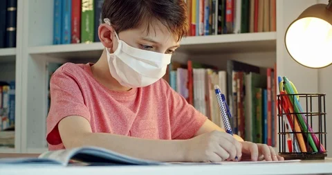 Student wearing protective mask working in isolation on school assignments. Stock Footage 126865647