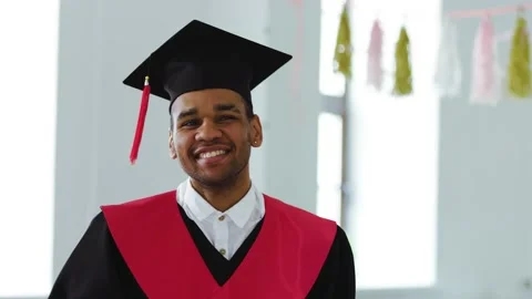 A student wearing square caps and a black and red gown in front of the screen Stock-Footage 191517094