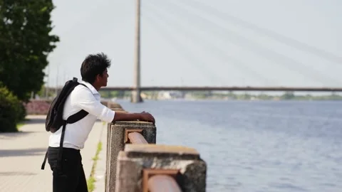 Student with white collar and backpack admires coastal city views Stock Footage 220339448