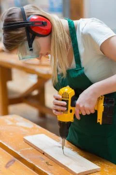 Student in a woodwork class using a drill Stockfoto's