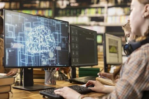 Student working with AI brain display on desktop computer in library 写真素材