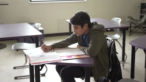 Student working at desk in classroom Stockbeeldmateriaal 221034276