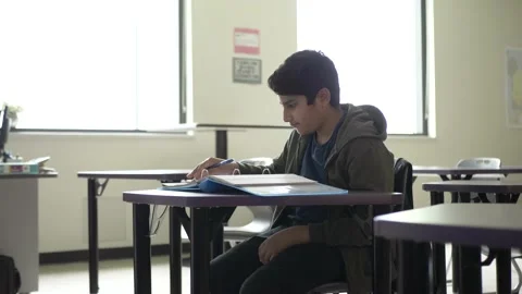 Student working at desk in classroom 库存影片 221034668