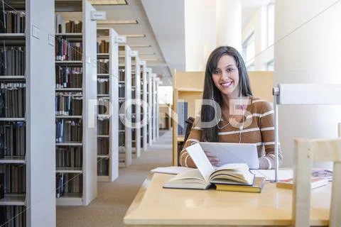 Student Working At Desk In Library
