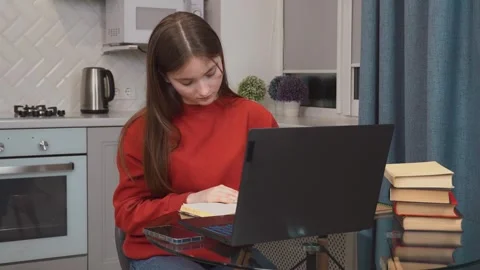 Student working from home using laptop and textbook Stock Footage 311780105
