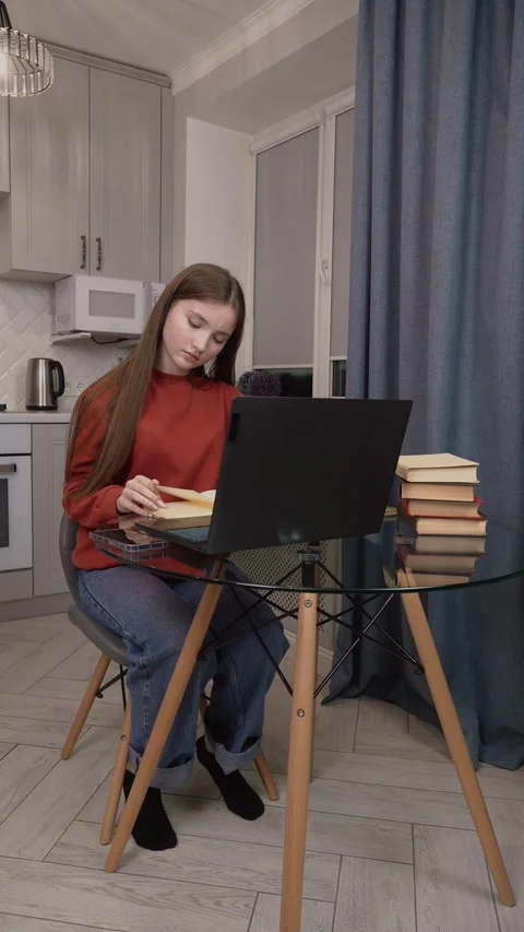 Student working from home using laptop and textbook Video stock 311780778
