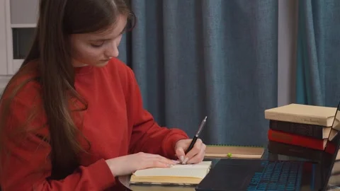 Student working from home using laptop and textbook 库存影片 311806978